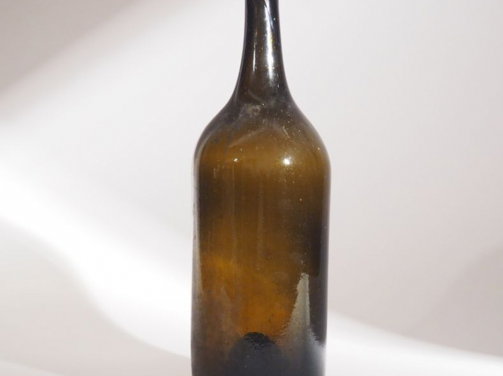 Bouteille XVIIIème en verre soufflé brun. H. : 38 cm.
