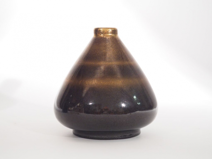 M. BRIANSAU. Vase conique en céramique noire et dorée. Signé. H. : 14,