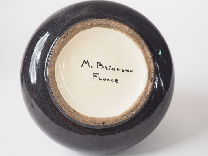 M. BRIANSAU. Vase conique en céramique noire et dorée. Signé. H. : 14,