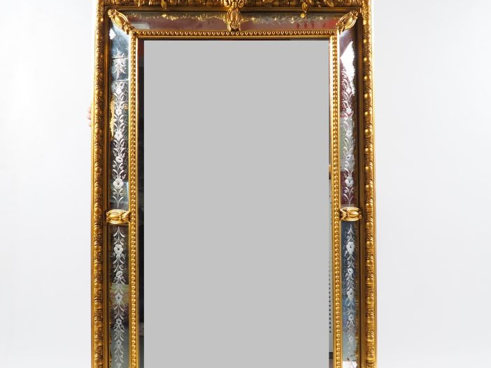 Grande glace à parecloses Napoléon III en bois et stuc doré, à décor d