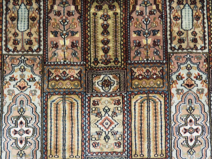 Grand tapis d'Orient en soie à décor de motifs géométriques et de fris