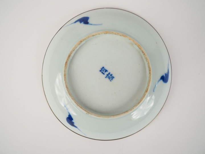 Petite assiette en porcelaine bleu blanc. Le pourtour cerclé de métal.