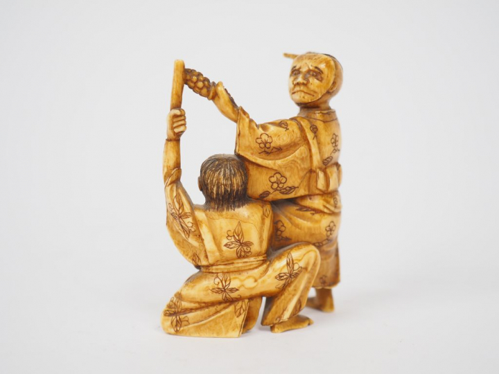 Petit okimono en ivoire représentant un acteur de théâtre accompagné d