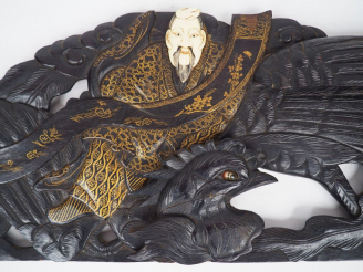 Vente aux enchères Corniche en bois sombre, sur lequel est assis un personnage aux vêteme