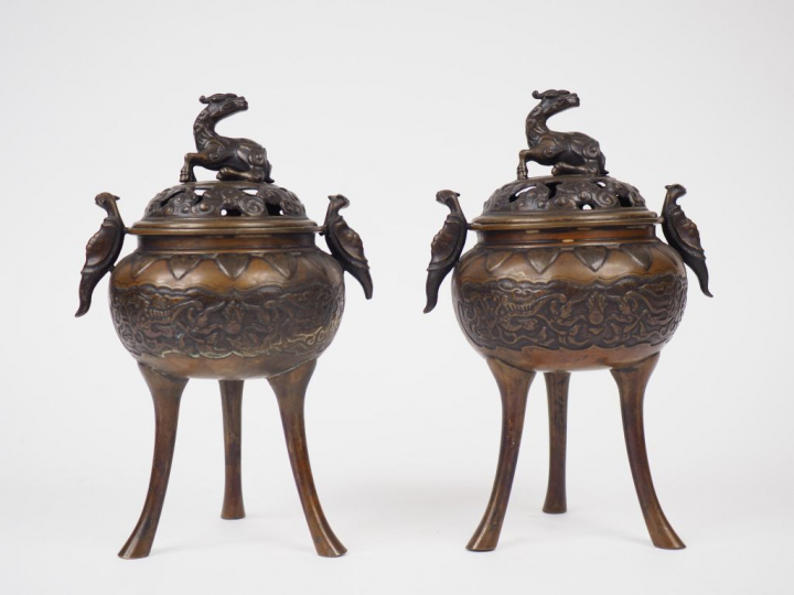 Paire de brûle-parfum tripodes en bronze de patine claire, à décor cis