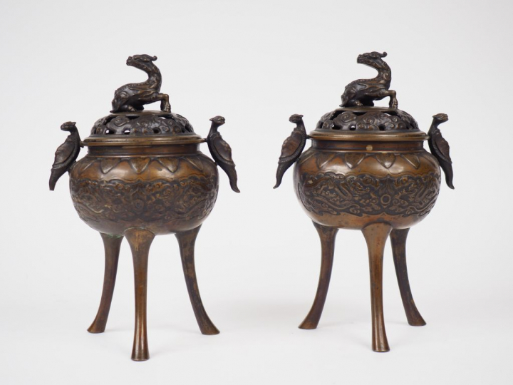 Paire de brûle-parfum tripodes en bronze de patine claire, à décor cis