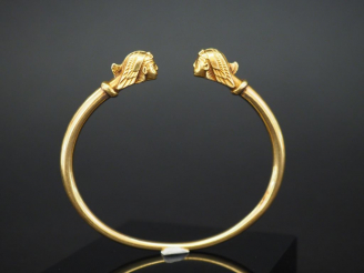 Vente aux enchères Bracelet jonc en or jaune, à décor de têtes de sphinx aux extrêmités. 