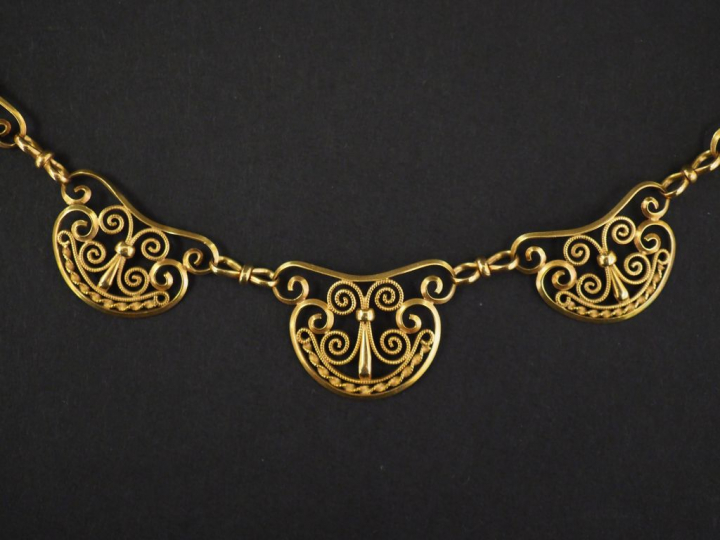 Collier en or jaune, composé de maillons à décor de filigranes.  Long.