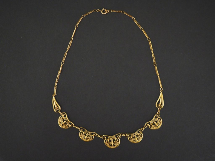 Collier en or jaune, composé de maillons à décor de filigranes.  Long.