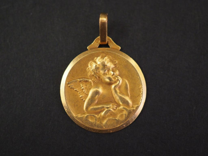 Médaille religieuse en or jaune, figurant un angelot. Diam. 1,9 cm Poi