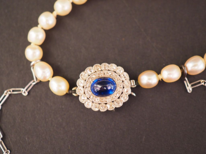 Collier de perles fines.  Fermoir en forme de marguerite ornée en son 