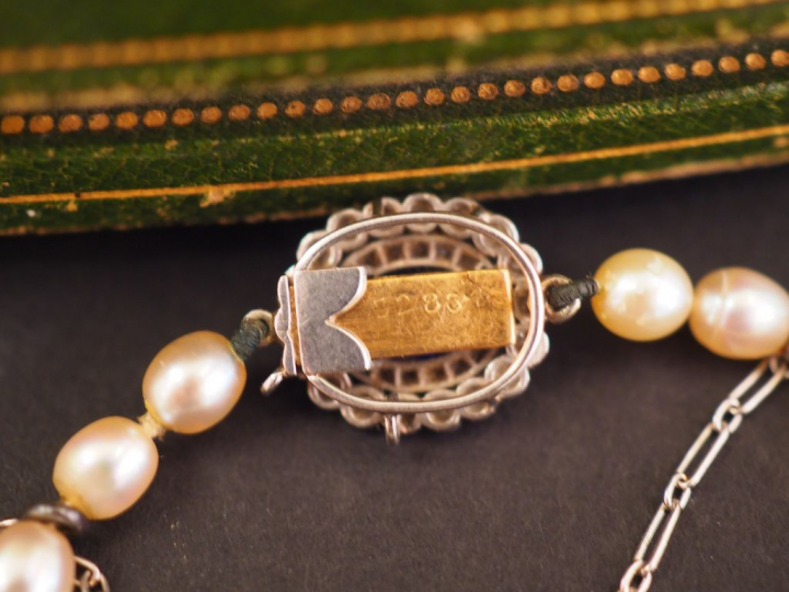 Collier de perles fines.  Fermoir en forme de marguerite ornée en son 