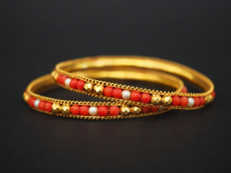 Vente aux enchères Paire de joncs en or jaune, perles et perles de corail. Diam. 6,5 cm P