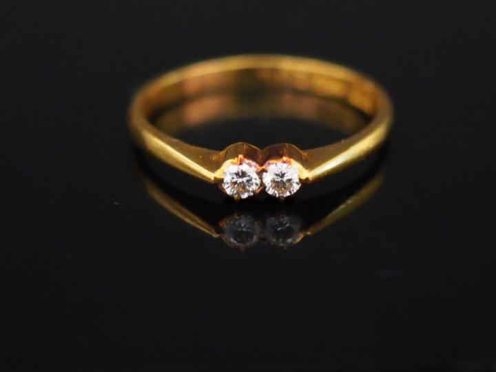 Bague en or jaune, sertie en son centre de deux petits diamants. TDD. 