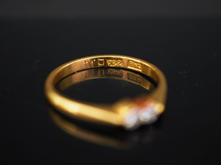 Bague en or jaune, sertie en son centre de deux petits diamants. TDD. 