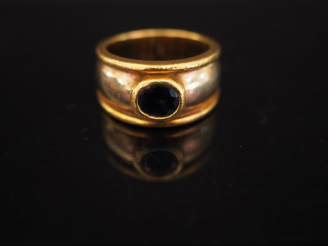 Vente aux enchères Bague deux tons d'or, ornée d'une pierre bleue en serti clos.  TDD. 45