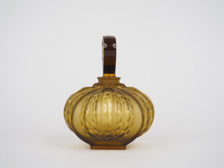 LALIQUE France.  Flacon en verre ambré. Signé.  H. 14 cm