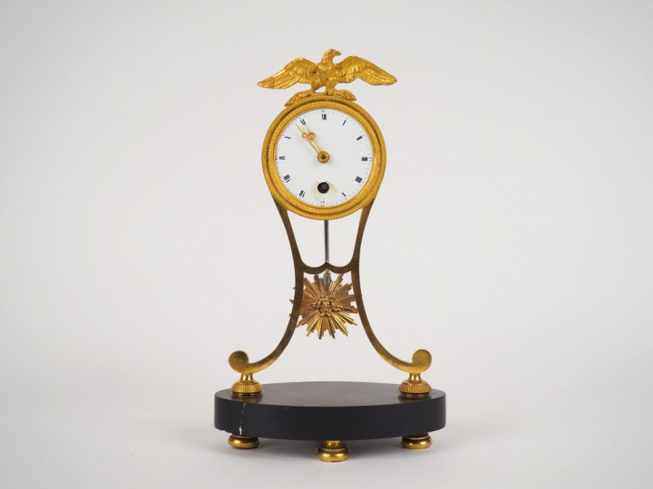 Petite pendulette de style Empire en métal et bronze doré, surmontée d