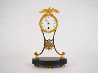 Vente aux enchères Petite pendulette de style Empire en métal et bronze doré, surmontée d