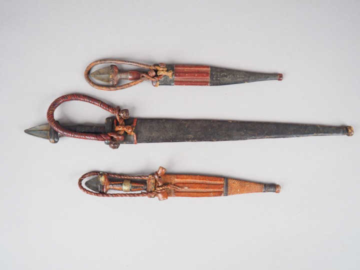 Lot de trois poignards à lame symétrique, fusée et fourreau habillés d