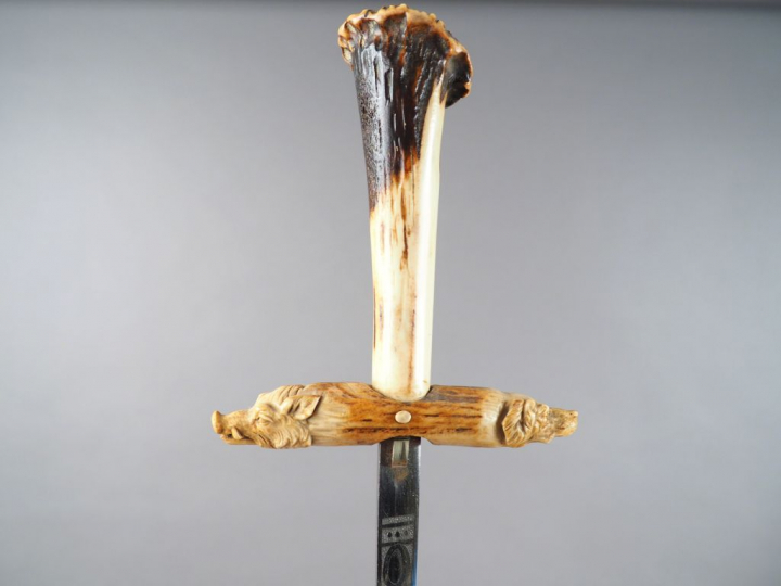 Dague de vènerie en corne sculptée, à décor de tête de chien de chasse