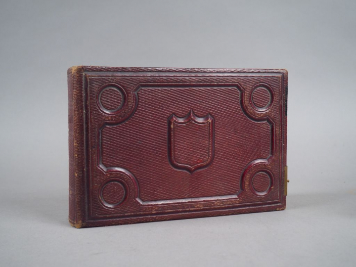 Album relié cuir rouge contenant 21 photos représentant une famille de