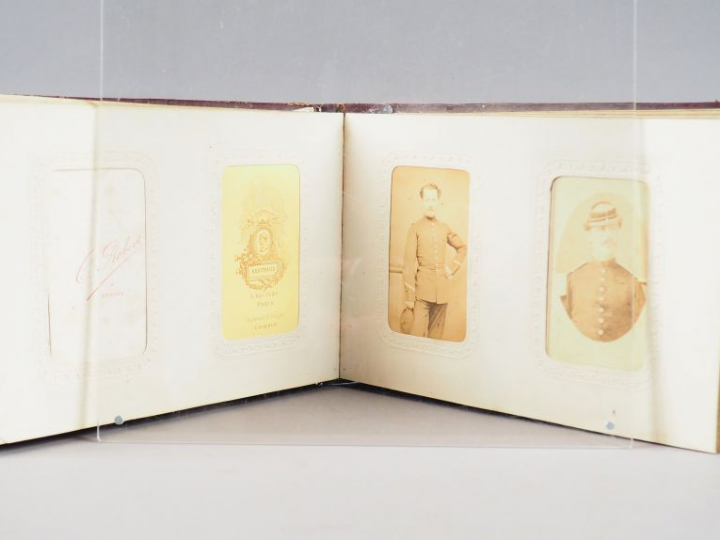 Album relié cuir rouge contenant 21 photos représentant une famille de