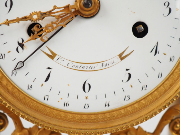 Pendule Empire en marbre bicolore blanc, noir et bronze doré à décor d