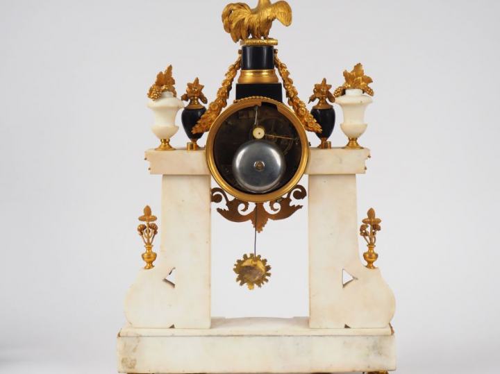 Pendule Empire en marbre bicolore blanc, noir et bronze doré à décor d