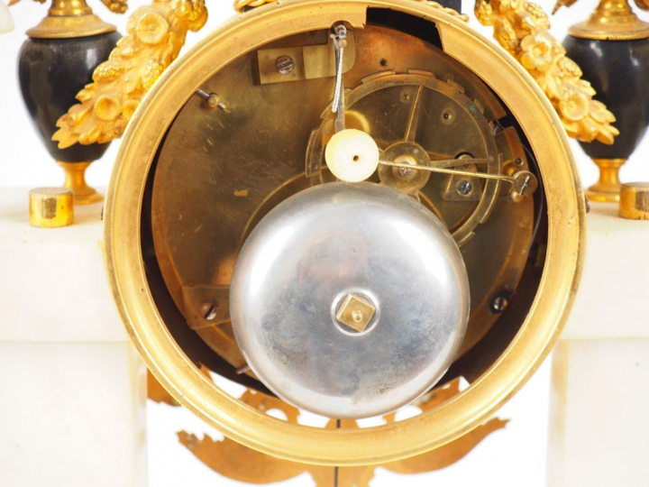 Pendule Empire en marbre bicolore blanc, noir et bronze doré à décor d