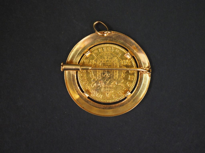 Pendentif transformable en broche, serti en son centre d'une pièce de 