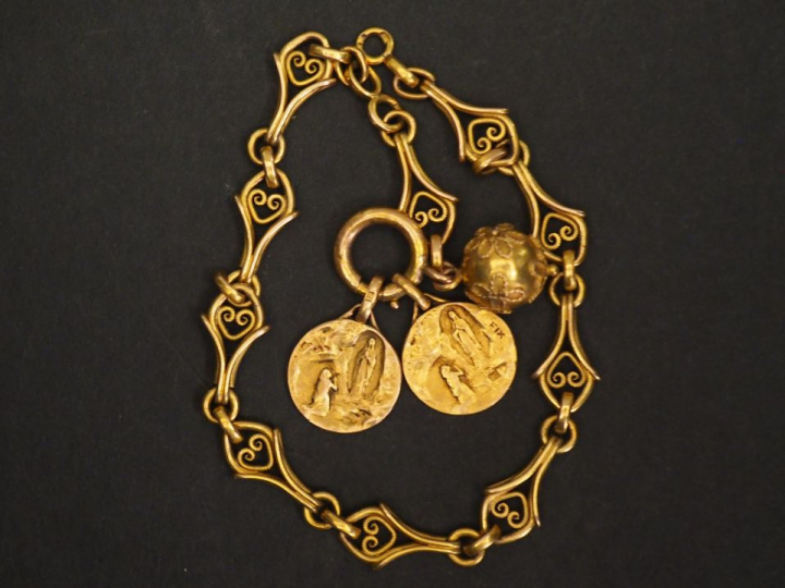 Bracelet en or à décor de lambrequins agrémenté d'une pendeloque et de