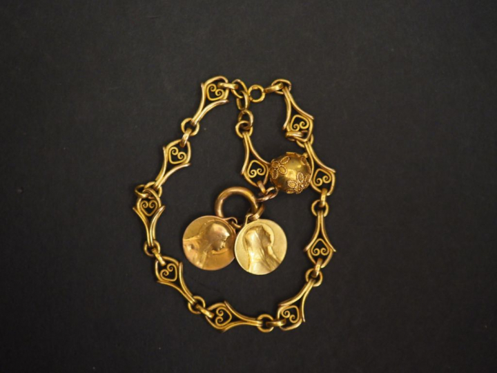 Bracelet en or à décor de lambrequins agrémenté d'une pendeloque et de