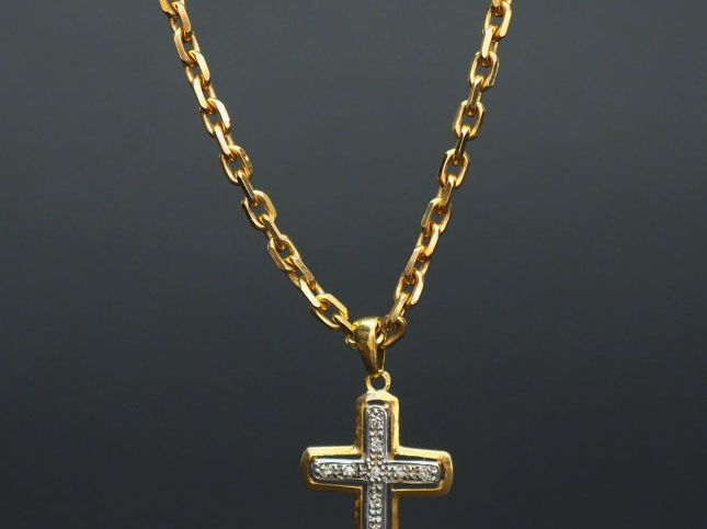 Collier en or, maille forçat et une croix en or agrementée de roses.  