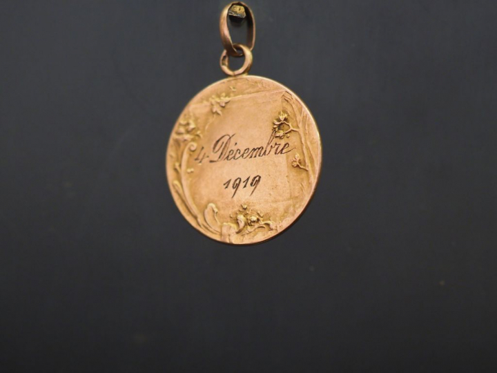 Médaille 1900 en or, à décor d'ange et de fleurs. Poids : 4,10 g