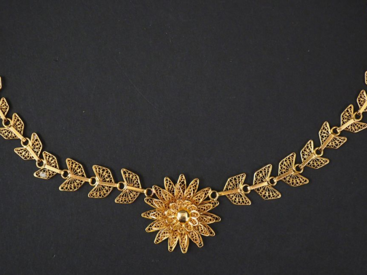 Collier en or filigranné, à décor de fleur et de papillons stylisés.  