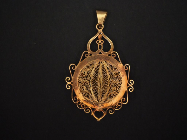 Pendentif en or filigrané à décor de fleur en relief.  Poids : 18,27 g