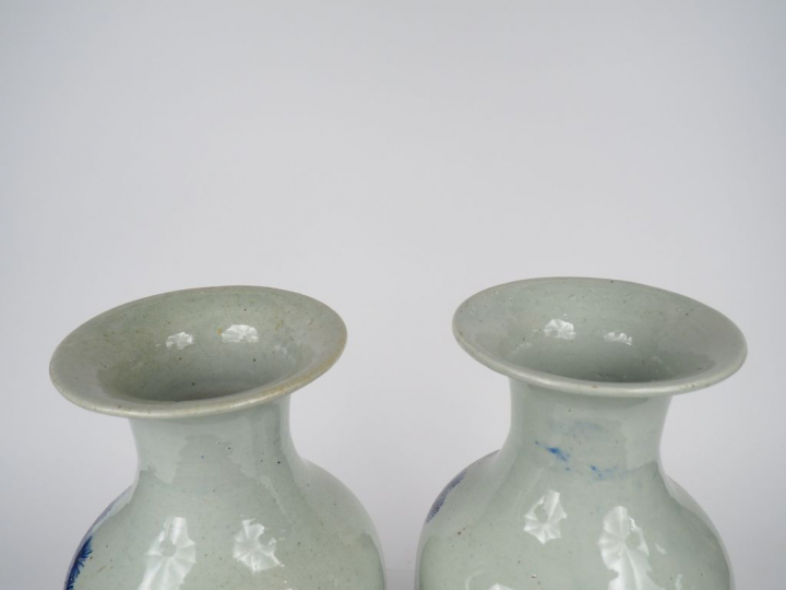Paire de vases balustre en porcelaine à décor en bleu sur fond céladon