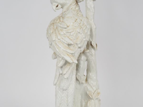Lampe en porcelaine blanche figurant un perroquet branché. H. 58,8 cm.