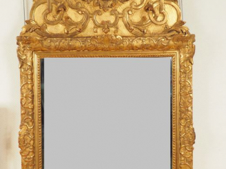 Vente aux enchères Glace XVIIIème en bois et stuc sculpté doré.  Fronton à décor de masca