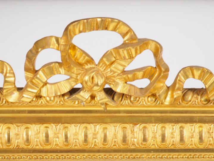 Grande glace en bois et stuc doré, de style Louis XVI à décor de frise