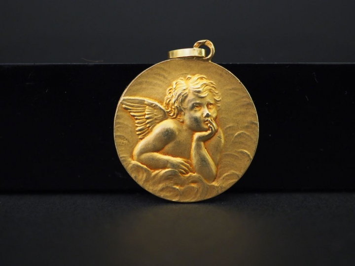 Médaille de baptême en or jaune, à décor d'un angelot.  Diam. 2,2 cm P
