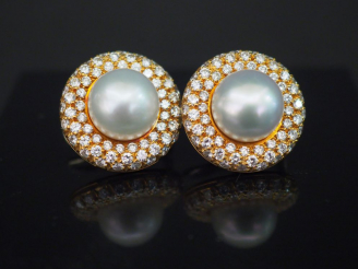 Vente aux enchères MIKAWA. Paire de perce oreilles, perles entourées de trois lignes de d