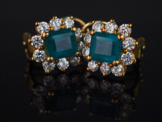 Vente aux enchères Paire de perce oreilles "marguerite", émeraude entourée de dix diamant