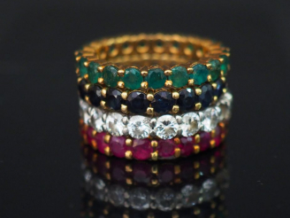 Vente aux enchères Bague quatre alliances, montures en or, rubis, diamants, saphirs, émer
