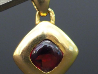 Vente aux enchères Petit pendentif en or en forme de losange orné d'une pierre rouge. Poi