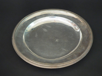 Vente aux enchères Plat rond début XIXème en argent, à décor d’une frise de feuilles d’ea