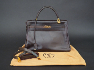 Vente aux enchères HERMES. Sac à main "Kelly" en cuir marron foncé. 28 cm (état d'usage) 