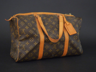 Vente aux enchères VUITTON. Petit sac de voyage en toile Monogram, anses et parements en 