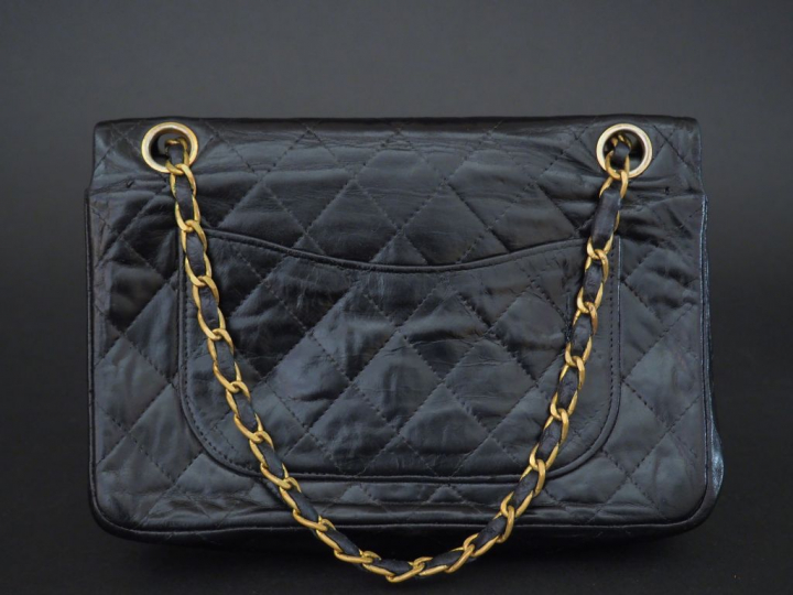 CHANEL. Sac à main en cuir noir matelassé (monogramme C. C à l'intérie